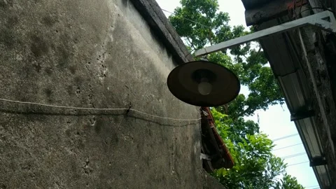 Footage of rustic outdoor lamp hangs on a weathered concrete wall. Stock Footage 320238048