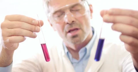Footage of a scientist explaining something about the content in two test tubes Stock Footage 48974517