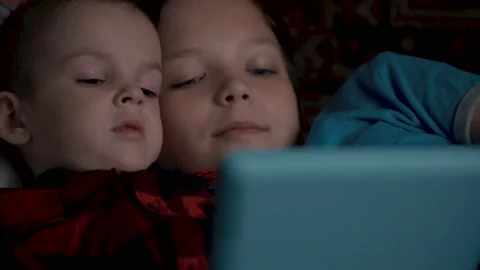 Footage two boys using tablet pc lying on sofa. 스톡 동영상 95595126