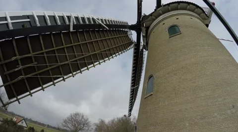 Footage of a typical dutch windmill sails moving by wind at a steady pace 4k Stock Footage 61395243