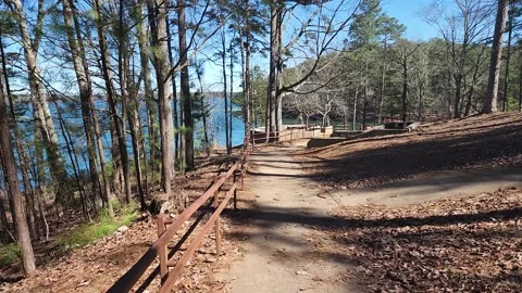 Footage walking along a footpath surrounded by the blue waters of Lake Lanier Video stock 233295013