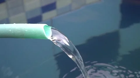 Footage of water dripping down the pool from a plastic hose Stock Footage 224031349