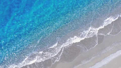 Footage of Waves Crashing on Sandy Beach in Sunny Weather With Clear Blue Water Stock Footage 322935359