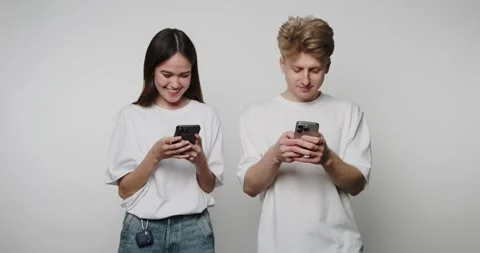 Footage of young couple smiles while texting on their phones, reflecting a .. Stock Footage 314522419