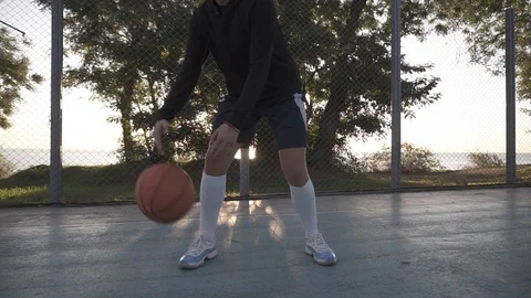 Footage of a young girl basketball player training and exercising outdoors on Stock Footage