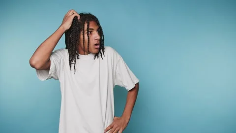 Footage of young man appears puzzled, scratching his head in contemplation,.. Stock Footage 314522370