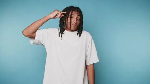 Footage of young man with dreadlocks poses thoughtfully, showcasing a light.. Stock Footage 314522374
