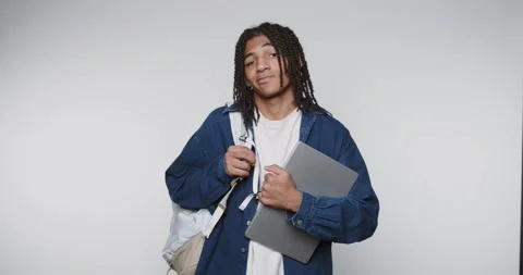 Footage of young man dressed casually with a laptop and a backpack on light.. Stock Footage 314773070