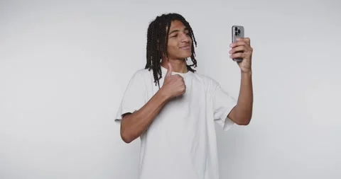 Footage of young man smiles while taking a selfie with his smartphone, expr.. Stock Footage 314773609