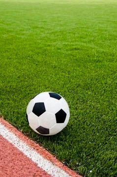 The football is on the artificial grass soccer field in the stadium. Stock Photos