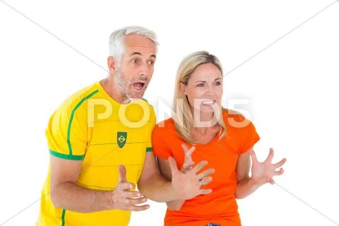 Football fan couple looking nervously ahead Stock Photos