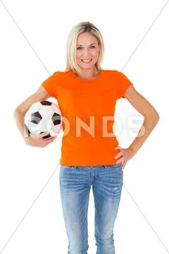 Football fan holding ball in orange tshirt Stock Photos