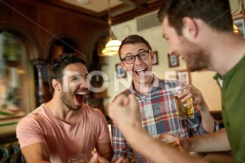 Football fans or friends with beer at sport bar Stock Photos