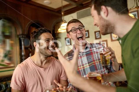 Football fans or friends with beer at sport bar Stock Photos