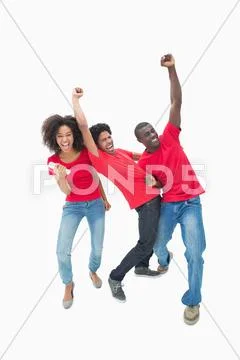 Football fans in red cheering together Stock Photos
