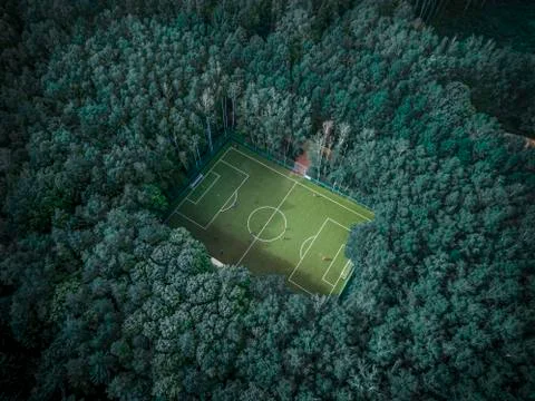 Football field lost among green summer trees in a Moscow park. Russia. Stock Photos