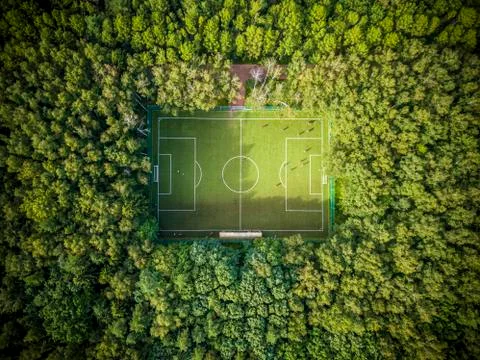 Football field lost among green summer trees in a Moscow park. Russia. Stock Photos