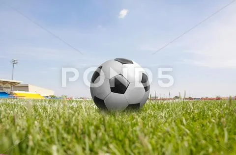 Football on green grass field Stock Photos