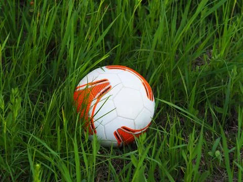 Football lies in the green grass Stock Photos