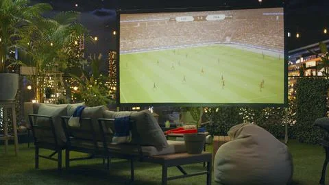 Football match viewing setup on empty rooftop terrace at night Stock Photos