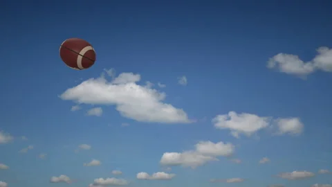 Football pass against a blue sky Stock Footage