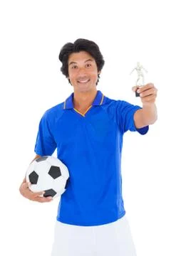 Football player in blue holding winners trophy Stock Photos