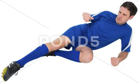 Football player in blue kicking Stock Photos