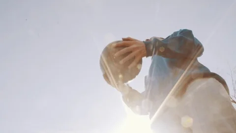 Football player heading the ball under blue sky at city park. Slow motion Stock Footage