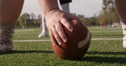 Football player hiking the ball to the quarterback Stock Footage