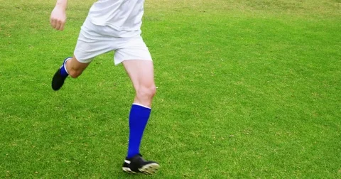 Football player kicking a ball in the field Stock Footage