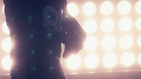 Football player putting on his gloves against stadium illumination lights Stock Footage 73103721