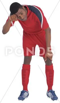 Football player in red catching his breath Stock Photos