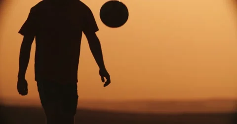 Football player silhouette , practicing with the ball,the sunset Golden hour Stock Footage