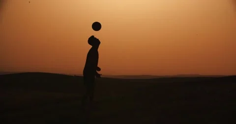 Football player silhouette , practicing with the ball,the sunset Golden hour Stock Footage