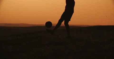 Football player silhouette , practicing with the ball,the sunset Golden hour Stock Footage