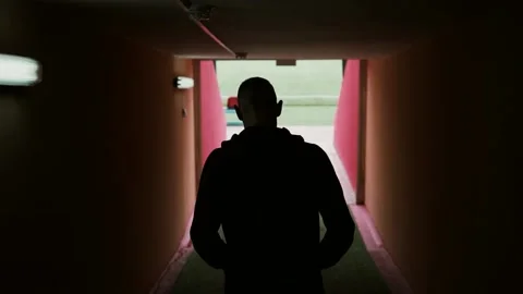 A football player walks through the tribune space and enters the football fi Stock Footage