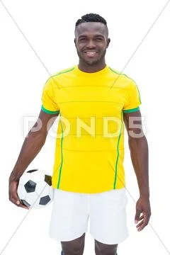 Football player in yellow standing with the ball Stock Photos