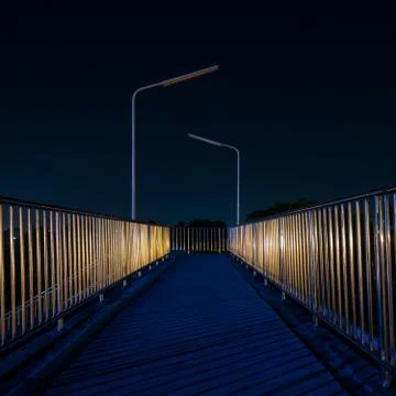 Footbridge with light reflection at night Stock Photos