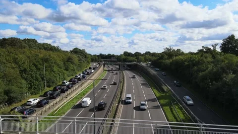 Footbridge spanning multilane highway surrounded by trees Stock Footage 164828773