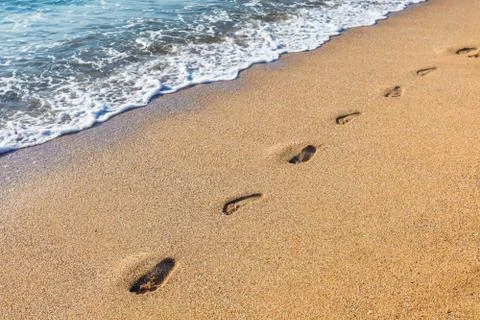 Footmarks on the sandy beach Stock Photos