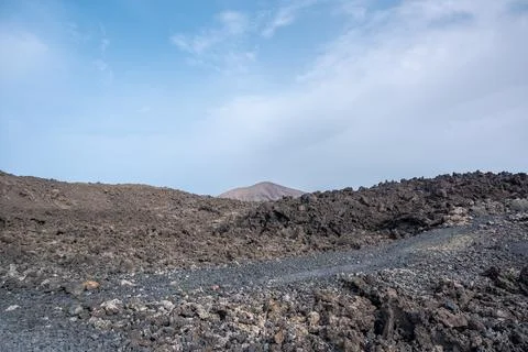 Footpath between lava with views of the Caldera Blanca volcano, Timanfaya, Ca Stock Photos