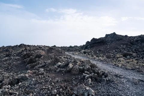 Footpath between lava with views of the Caldera Blanca volcano, Timanfaya, Ca Stock-Fotos