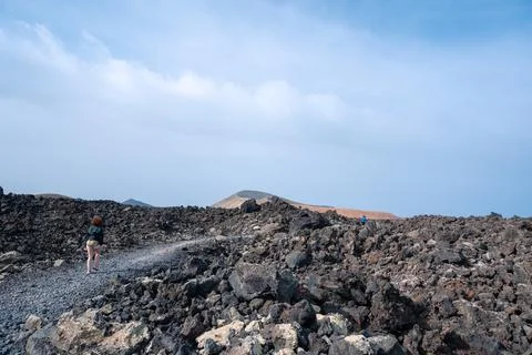 Footpath between lava with views of the Caldera Blanca volcano, Timanfaya, Ca Stock Photos