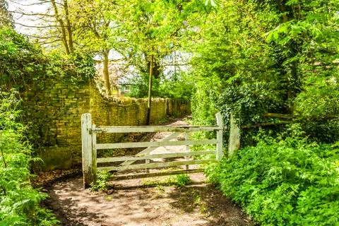 Footpath next to a wall with large white five bar gate. Chipping Norton Stock Photos