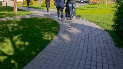 Footpath of paving slabs on which close-up feet of walking people in park Stock-Footage 112321498