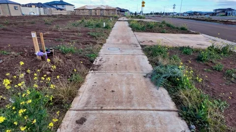 A footpath surrounded by vacant land and construction site in Australia Vídeos de archivo 312423554