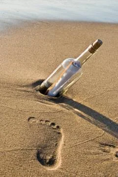 Footprint by message in a bottle Stock Photos