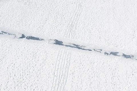 Footprints and sledge marks on the snow viewed from drone above Stock Photos