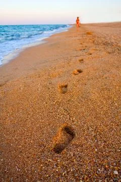 Footprints on beach in evening Stock Photos