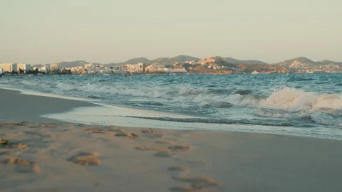 Footprints at empty beach and sea at Playa d'en Bossa in Ibiza, Spain Stock Footage 129554711